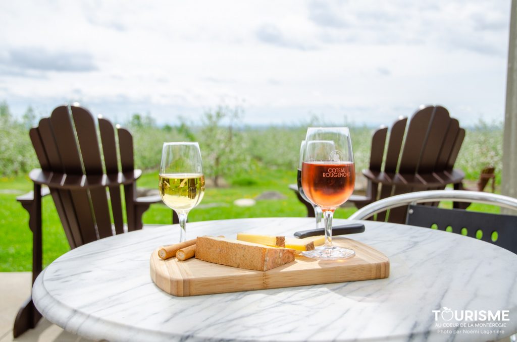 Coupes de vin et dégustation sur la terrasse de Coteau Rougemont. Crédit photo: Noémi Laganière